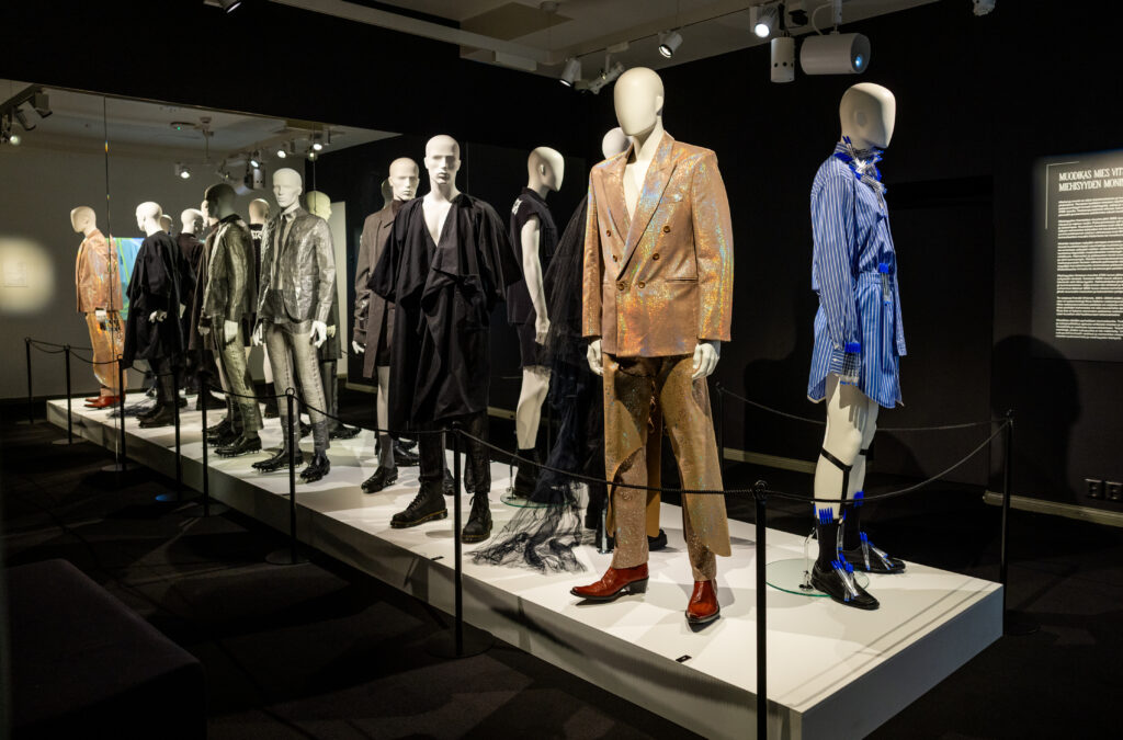 Mallinuket näytöslavalla, päällä miesten vaatteita.